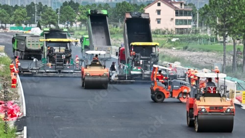 Construction site is laying new asphalt pavement, road construction workers and road construction machinery scene. Highway construction site scene. blurred work scene.