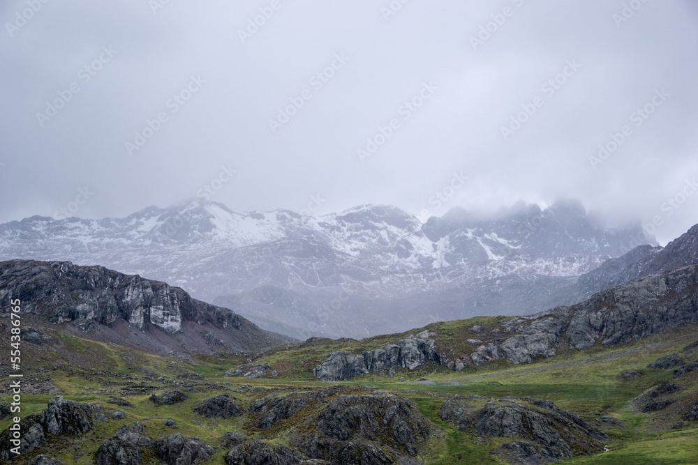 una montaña de glaciar o nevado, una montaña de rocas y un paisaje verde, en un día lleno de neblina, en Perú Sudamérica
