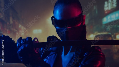 Cyberpunk ninja girl in a mask and with a katana. Beautiful female samurai woman on the background of Asian city downtown. photo