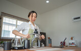 Asian women use a manual process to make espresso with a classic espresso machine at home.