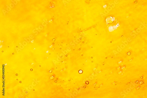 strong extract of gold cannabis wax with high thc close up, bubble shatter texture photo