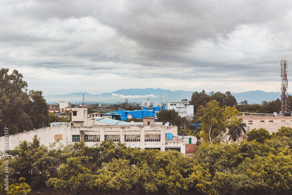 View of the industrial area against cloudy sky and distant mountains
