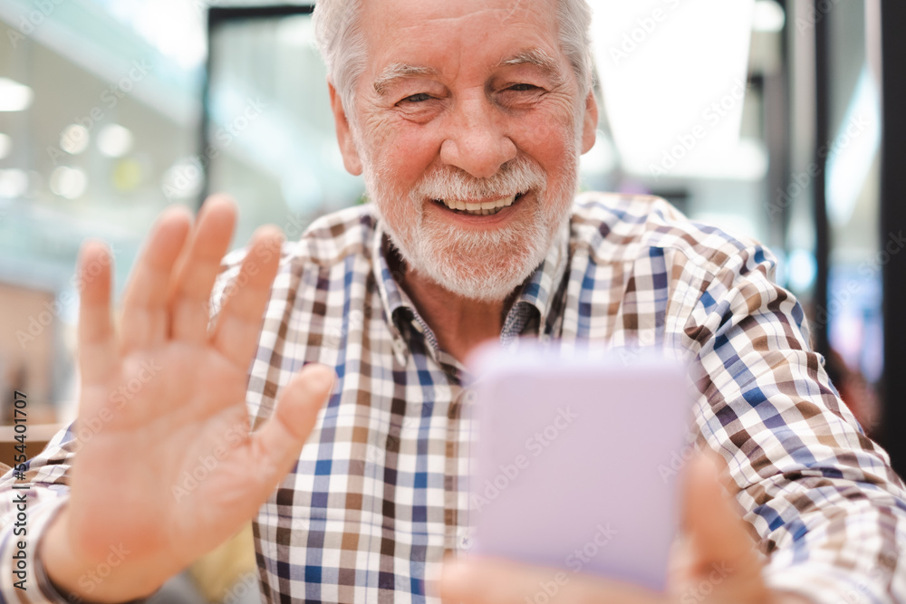 Portrait of happy caucasian senior man video talking on mobile phone in video call - handsome bearded elderly man sitting using smartphone Portrait of happy caucasian senior man video talking on mobile phone in video call - handsome bearded elderly man sitting using smartphone