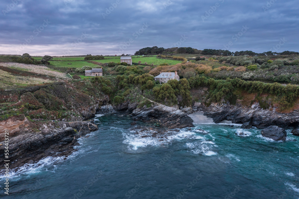 Beautiful aerial drone landscape image of Prussia Cove at sunrise in Cornwall England with atmospheric daramatic sky and clouds