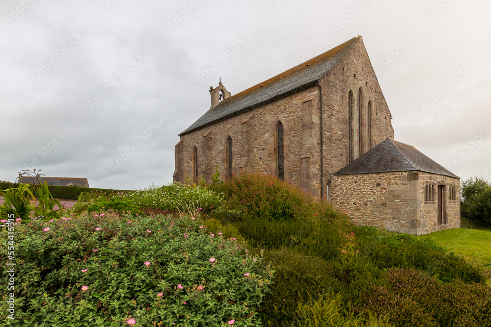 Fototapeta premium An old church in a green field in a gloomy weather