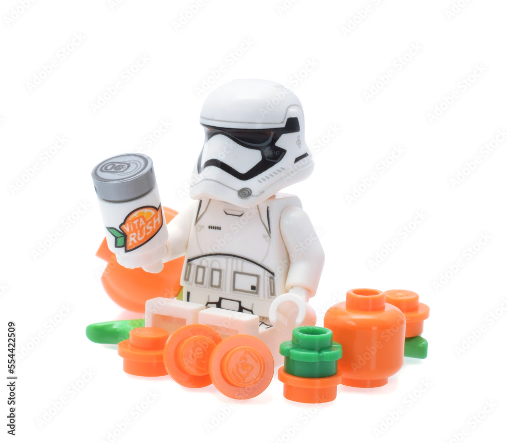 Naklejka premium Lego minifigure of warrior Star Wars with orange fruits and drink can isolated on white. Editorial illustrative image of popular plastic toy constructor.