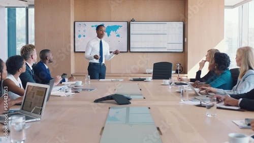 Corporate, business people and map analytics presentation in boardroom with interracial workforce. Business meeting, communication and black man presenting statistics analysis in Chicago, USA.