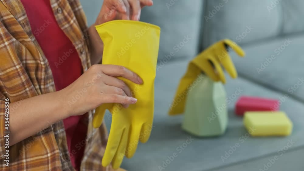 unrecognizable woman is tired of cleaning the house, angrily takes off and throws away rubber yellow gloves. unrecognizable woman is tired of cleaning the house, angrily takes off and throws away rubber yellow gloves.