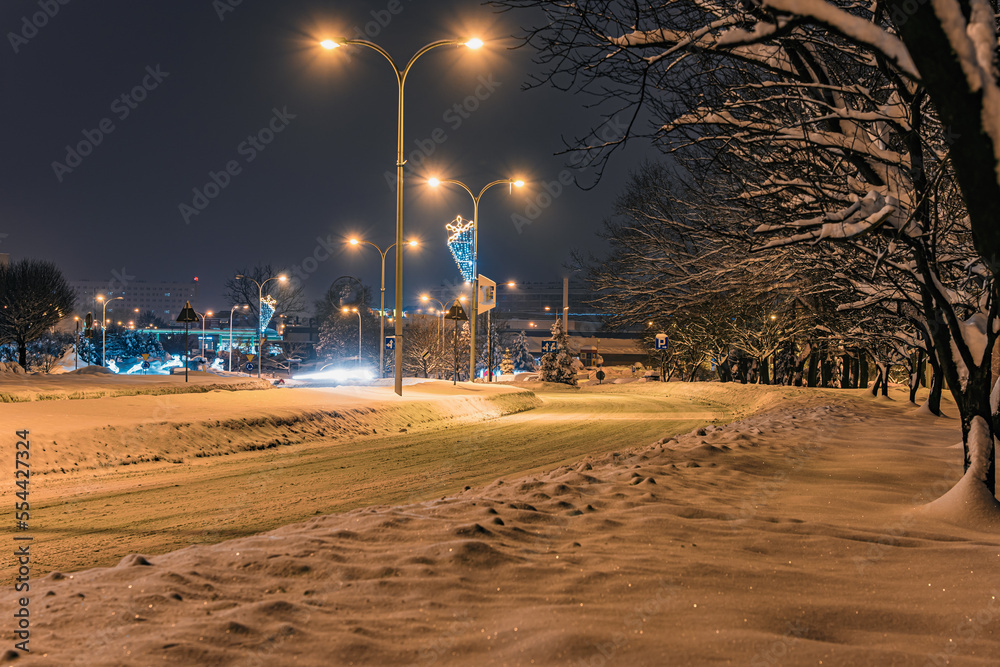 Mocno zasypane śniegiem droga i chodnik w mieście przemysłowym na Śląsku w Polsce, Jastrzębie-Zdrój nocą. - obrazy, fototapety, plakaty 