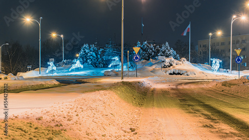 Mocno zasypane śniegiem droga i chodnik w mieście przemysłowym na Śląsku w Polsce, Jastrzębie-Zdrój nocą.