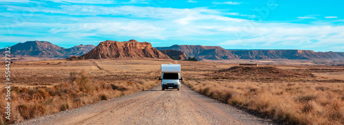 Foto Desert landscape of the Bardenas Real in Navarra Spain with motorhome on the roa