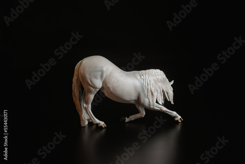 Black toy horse isolated on black background
