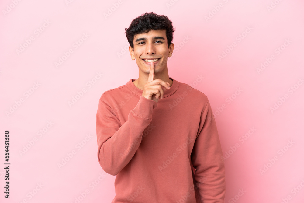 Young Argentinian man isolated on pink background showing a sign of silence gesture putting finger in mouth Young Argentinian man isolated on pink background showing a sign of silence gesture putting finger in mouth