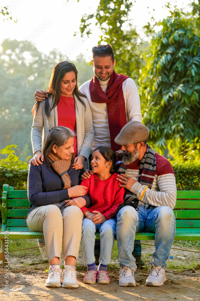 happy Indian family sitting at park in winter wear or warm clothes happy Indian family sitting at park in winter wear or warm clothes
