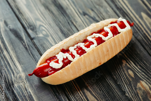 hot dog with smoked sausage and mayonnaise on wooden background