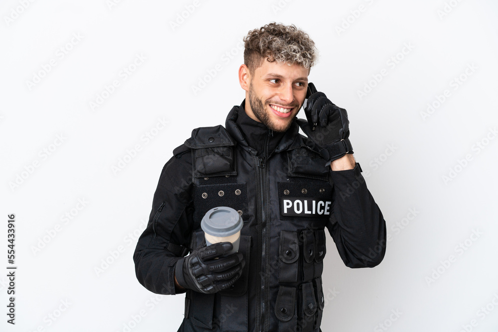 SWAT caucasian man isolated on white background holding coffee to take away and a mobile SWAT caucasian man isolated on white background holding coffee to take away and a mobile