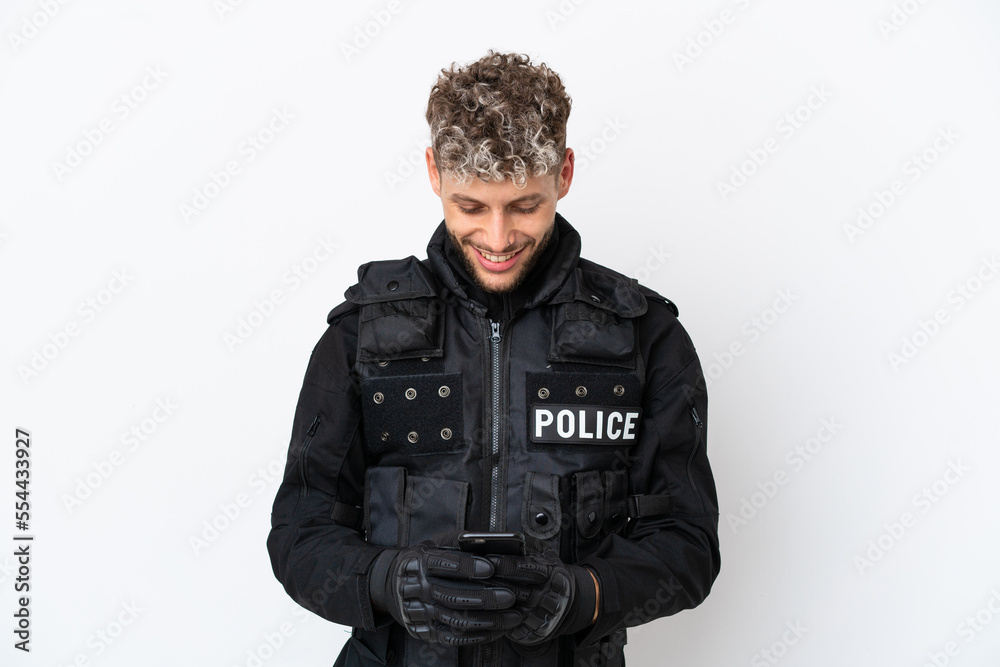 SWAT caucasian man isolated on white background sending a message with the mobile SWAT caucasian man isolated on white background sending a message with the mobile