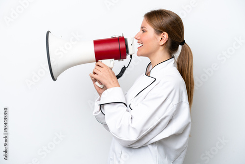 Young chef woman isolated on white background shouting through a megaphone