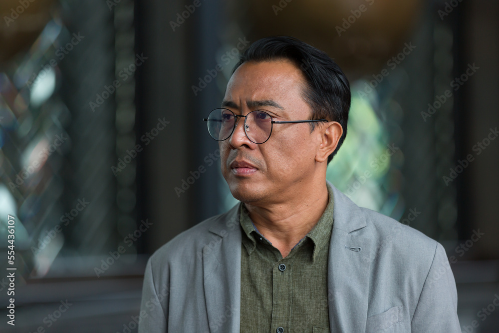 Naklejka premium Close up of headshot Asian business man wear glasses and suit standing in the office