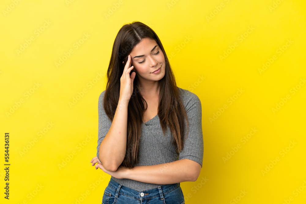 Young Brazilian woman isolated on yellow background with headache Young Brazilian woman isolated on yellow background with headache