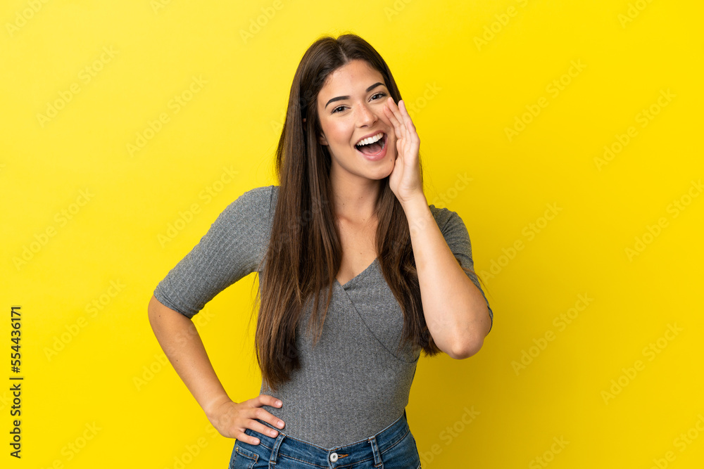 Young Brazilian woman isolated on yellow background shouting with mouth wide open Young Brazilian woman isolated on yellow background shouting with mouth wide open