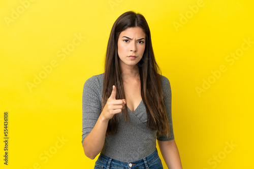 Fotografia Young Brazilian woman isolated on yellow background frustrated and pointing to t