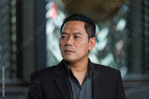 Closeup of headshot Asian business man wear suit standing in the office