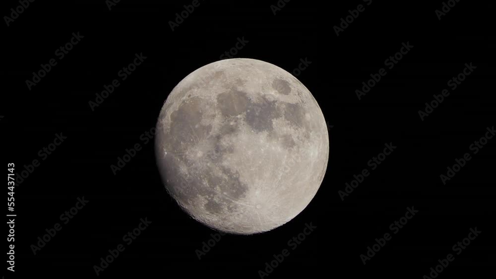 The full Moon moves across the sky at night. Shot through a telephoto lens The full Moon moves across the sky at night. Shot through a telephoto lens