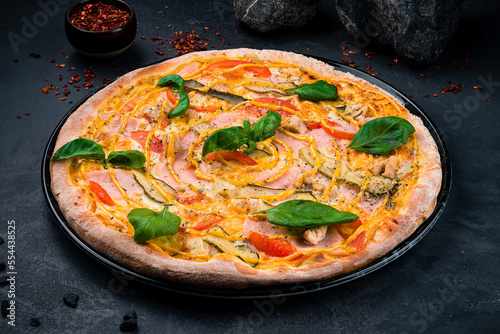 Pizza with Mozzarella cheese, Cheddar cheese, chicken ham, chicken fillet, mustard, cucumbers, tomatoes, oregano and basil.