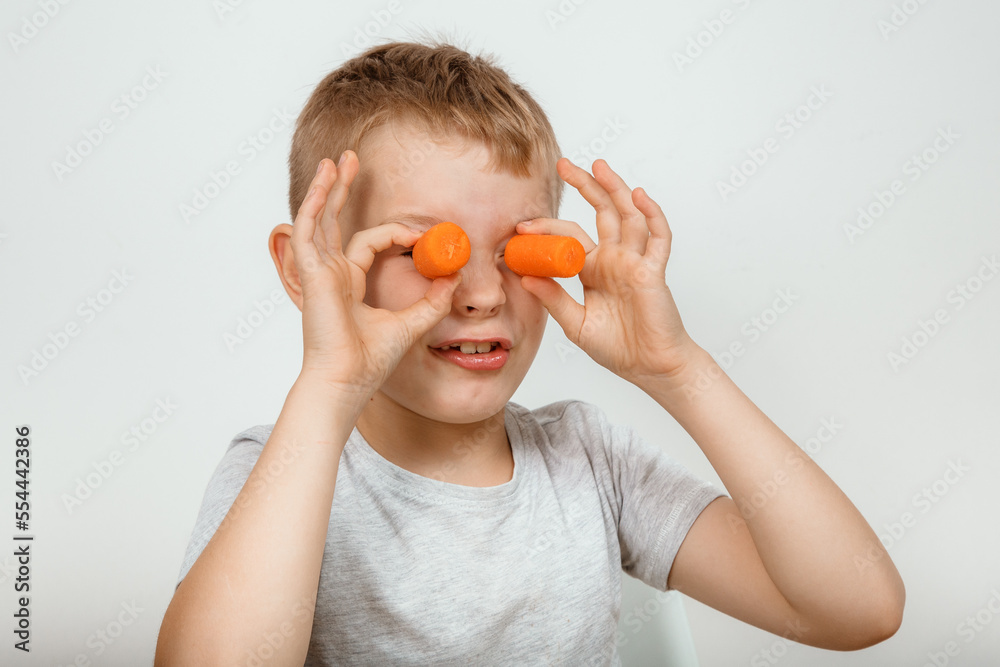Little boy biting the carrot, isolated on white Little boy biting the carrot, isolated on white