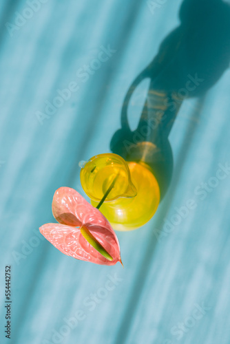 おしゃれで近代的な青い背景のアンスリウムと黄色い花瓶。