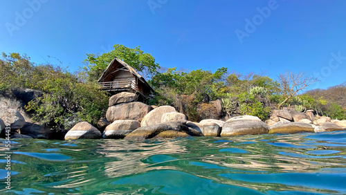 A unique water view of quaint, rustic holiday chalets or huts on the beautiful island resort on Mumbo Island in Lake Malawi.