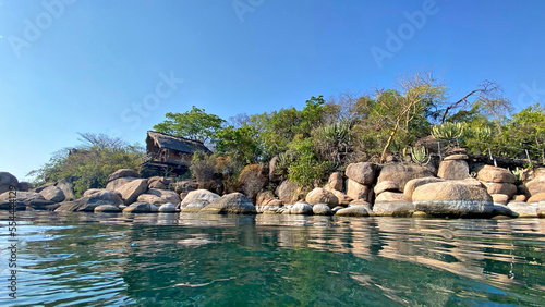A unique water view of quaint, rustic holiday chalets or huts on the beautiful island resort on Mumbo Island in Lake Malawi.