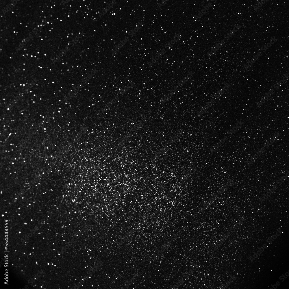 Black bokeh texture on black background. White glitter or illuminated dust