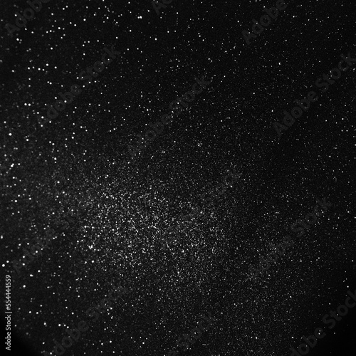 Black bokeh texture on black background. White glitter or illuminated dust