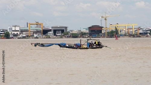 A fishing boat is sailing on the Chao Phraya River, Samut Prakan, Thailand photo