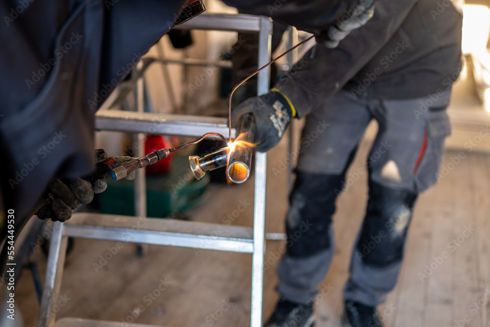 Man welding a gas pipe with flames and sparks Man welding a gas pipe with flames and sparks