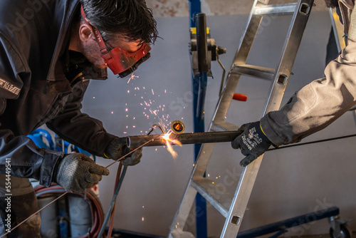 Man welding a gas pipe with flames and sparks