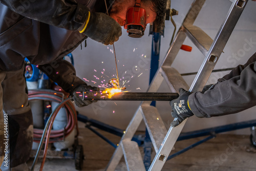 Man welding a gas pipe with flames and sparks