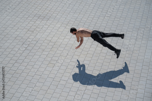 A man doing push-ups with flying outdoors.