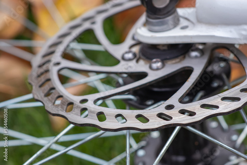 Bicycle disk brakes close up, grey metal disc attached to bike wheel, effective popular mountain bicycle brakes.