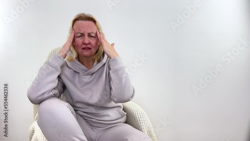 A woman holds head with his hands. Sensation of headache, migraine and dizziness. Headaches from stress or overwork. On examination by a doctor Close-up of woman who is worried about migraines photo