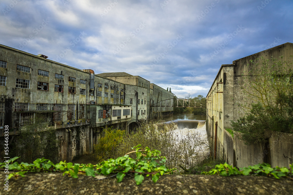 Old abandoned Matrena factory in the river margins with a little waterfall. Old factory in the margins of the Nabao river in the city of Tomar - Portugal Old abandoned Matrena factory in the river margins with a little waterfall. Old factory in the margins of the Nabao river in the city of Tomar - Portugal