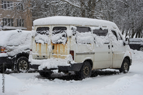 Cars covered in a thick layer of snow during a snowstorm