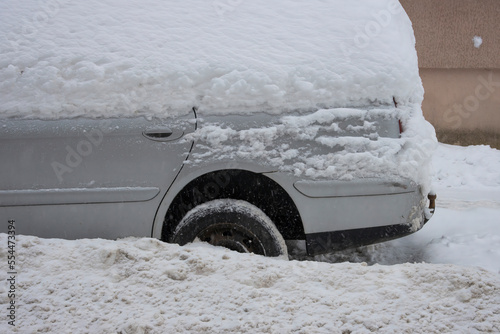 Close-up of parked cars covered in a thick layer of snow during a snowstorm
