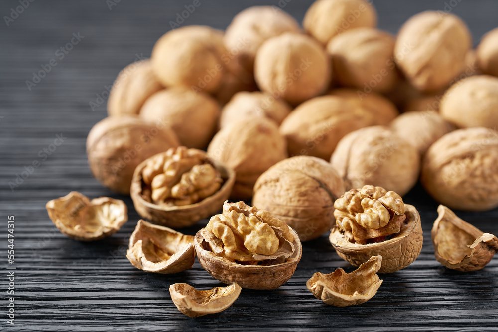 walnuts heap on a black table, selective focus. walnuts heap on a black table, selective focus.