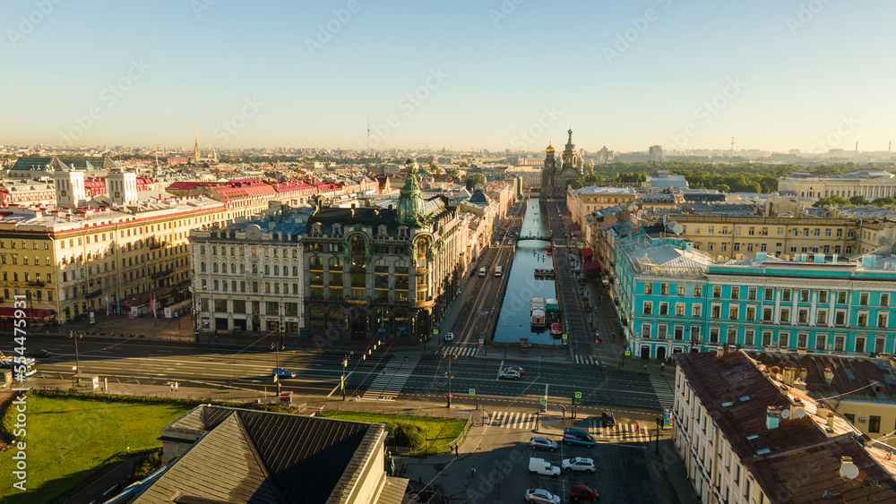 Aerial side view of the river channel, main street, Kazan Cathedral in the historical city of St. Petersburg at sunny summer dawn, the drone flies straight, old gold
