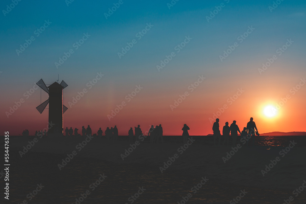A group of people at sunset after a hard day work returns to the mill A group of people at sunset after a hard day work returns to the mill
