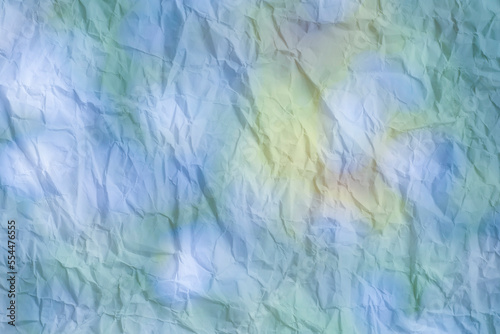 Crumpled paper with colorful spots as a background.