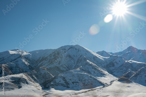 Foto beautiful glare of the sun illuminates snowcapped mountains